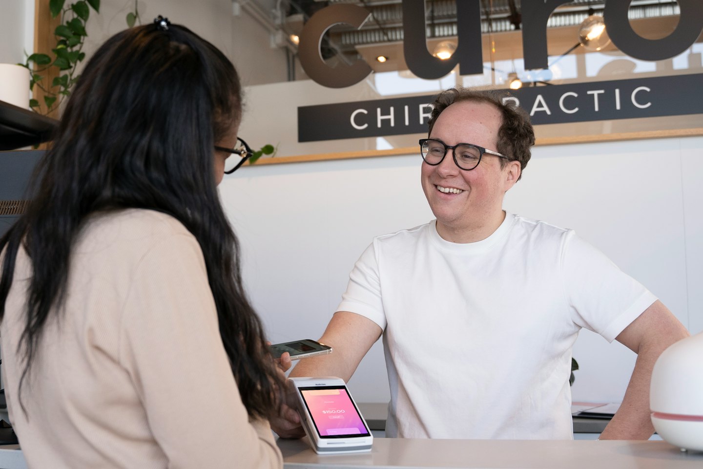 Un professionista del servizio sorride mentre assiste un cliente con il pagamento.